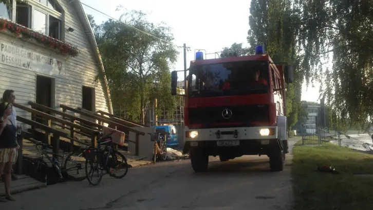 Feuerwehrfahrzeug vor einem Bootshaus