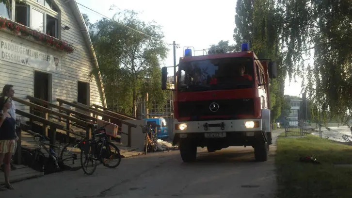 Feuerwehrfahrzeug vor einem Bootshaus