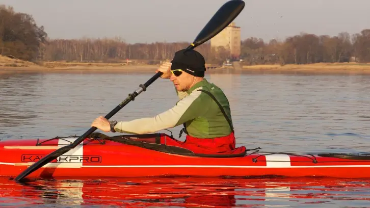 Kajakfahrer in einem roten Boot auf einem Fluss