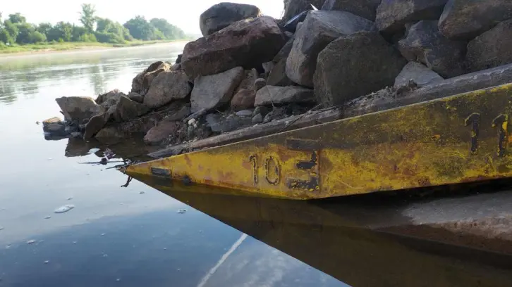 Gelbe, schräg ins Wasser verlaufende Pgelmesslatte