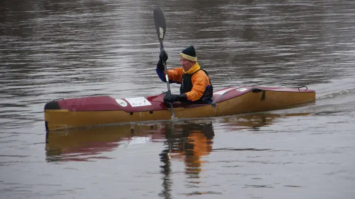 Winterlich gekleiderter Mann in einem Paddelboot