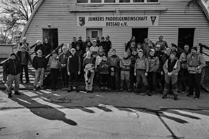 Ungefähr 50 Personen stehen vor dem Bootshaus der Junkers Paddlergemeinschaft