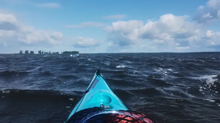 Der Bug eines Paddelbootes auf einem großen See.